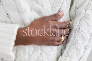 Horizontal stock photo of a woman wearing a chunky white sweater.