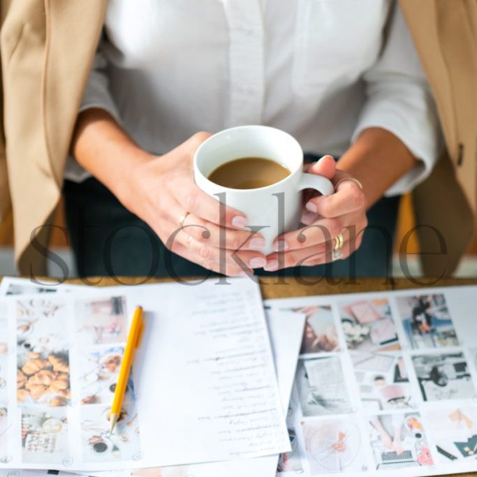 Vertical stock photo of woman with coffee cup working